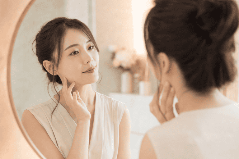 30歲女性照鏡子檢視臉部肌膚狀態